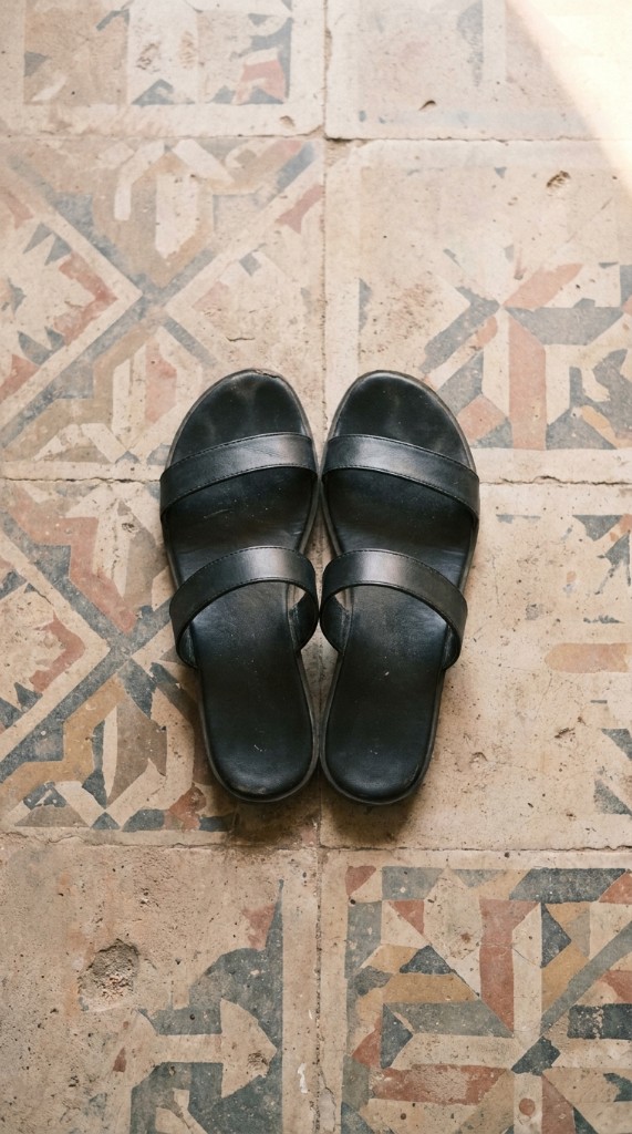 Black sandals on patterned floor