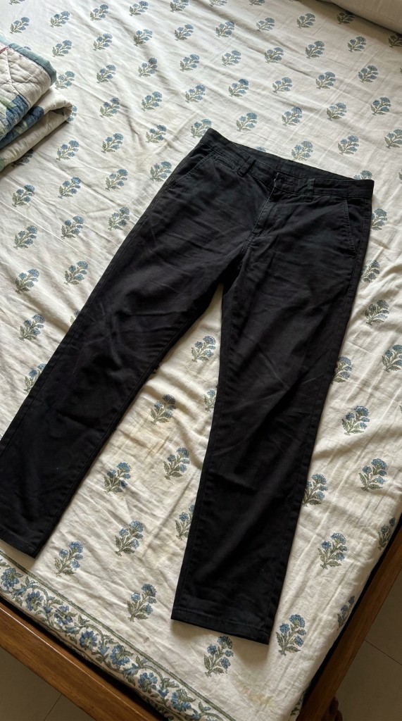 Black trousers on bed